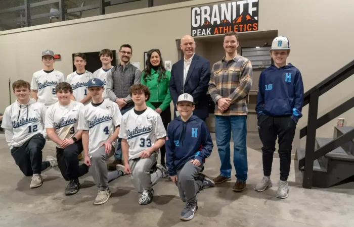 Governor Gianforte, Secretary Jacobsen celebrate record business creation in 2024 3 A youth baseball team and five adults pose indoors in front of a Granite Peak Athletics sign. The players wear Highlanders uniforms and caps, while the adults stand behind them, smiling—celebrating community and business creation in 2024.