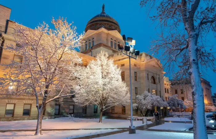 Secretary Christi Jacobsen: 'More than 10,000 new businesses registered in September, October' 5 A historic building with a domed roof, illuminated at dusk and surrounded by snow-covered trees, stands serene. The calm winter evening is reminiscent of new businesses registered by Secretary Christi Jacobsen, marking growth amid frosted tranquility.