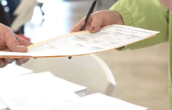 Secretary Christi Jacobsen refers alleged double voters to Montana’s U.S. Attorney 7 A voter hands in a ballot to an election official during a Montana election.