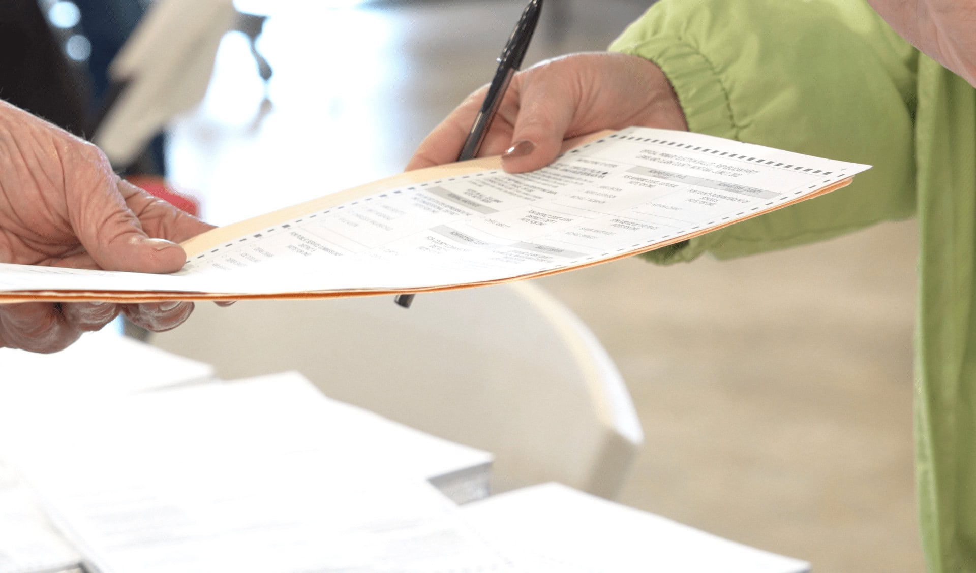 A voter hands in a ballot to an election official during a Montana election.