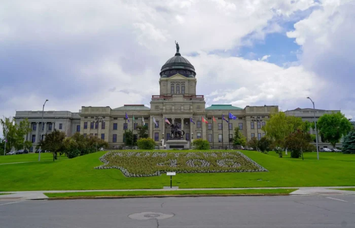 Board of State Canvassers completes State Canvass for 2022 Primary Election 5 The Montana State Capitol building with its domed roof stands proudly amid green lawns and state flags, while a floral design graces the grass in front—capturing the spirit reflected during the 2022 Primary Election.