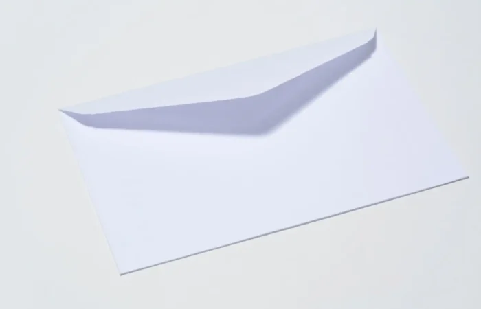 A white envelope is shown on a plain light background with its flap partially open, resembling the misleading mailings often received by newly registered businesses, such as those flagged by the Montana Secretary of State.