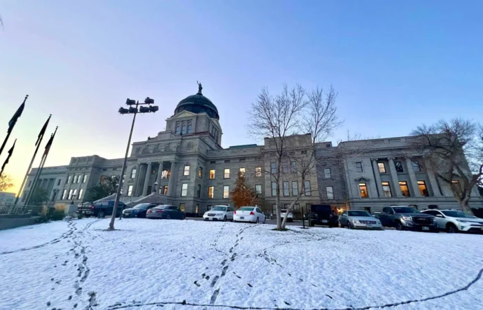 Secretary Christi Jacobsen: 'New business registrations surge again to open 2023' 9 A historic stone building with a central dome stands under a clear sky, surrounded by parked cars and snow-covered ground crisscrossed with footprints. Leafless trees line the front—an iconic scene during Montana precincts election results tally.