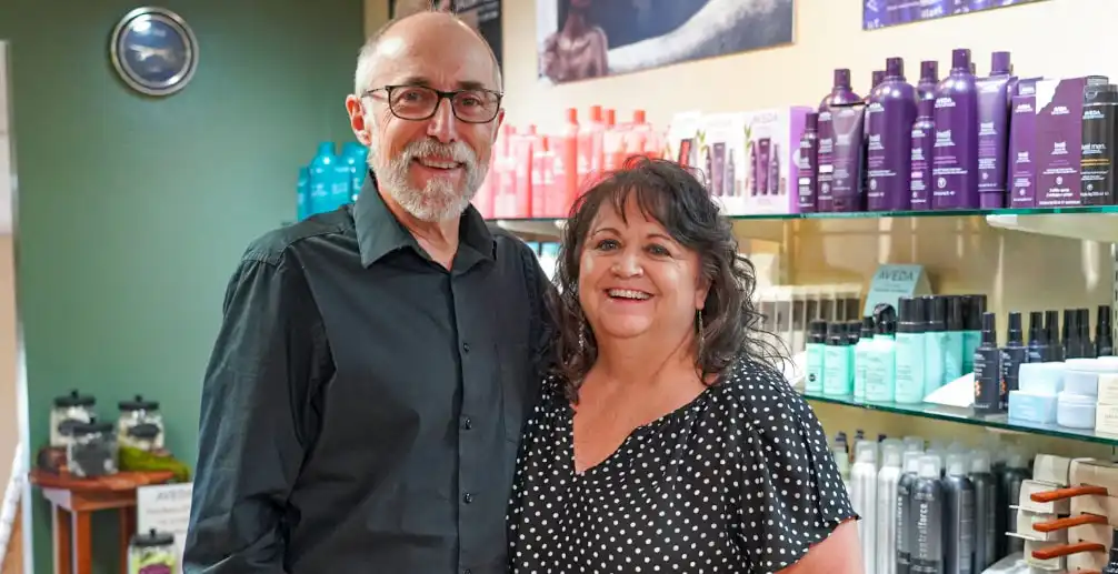Montana Business Spotlight: Helena's Futura Lane salon exemplifies the Golden Rule 20 A smiling man and woman stand together in a salon, with shelves of colorful hair care products behind them. The man wears glasses and a black shirt, and the woman wears a black polka dot blouse.