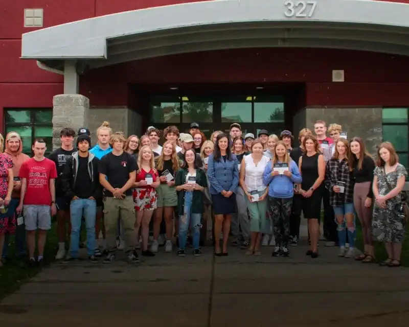 Secretary Jacobsen fulfilling campaign promise, delivers constitutions to Hamilton High School 1 A large group of Hamilton High School students and several adults, including Secretary Jacobsen, stand together outside a brick building, posing and smiling for a group photo on the sidewalk in front of glass doors.