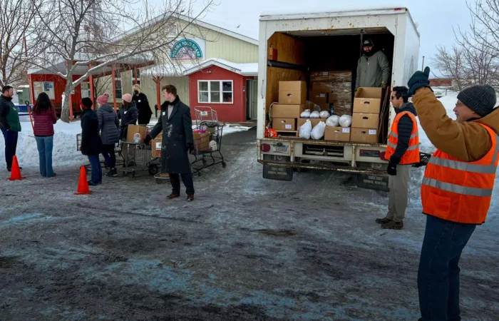 Helena Food Share provides holiday meals in effort to 'create hunger-free community' 10 People in winter clothing stand near a truck unloading boxes and bags for Helena Food Share in a snowy parking lot, with some loading=