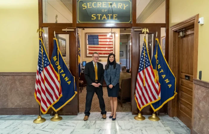 Montana's 2022 candidate filing season comes to a close 1 Two people stand in front of Montana and U.S. flags at the entrance to the Secretary of State office. An American flag is displayed inside, and the area has marble floors and wood-paneled doors.