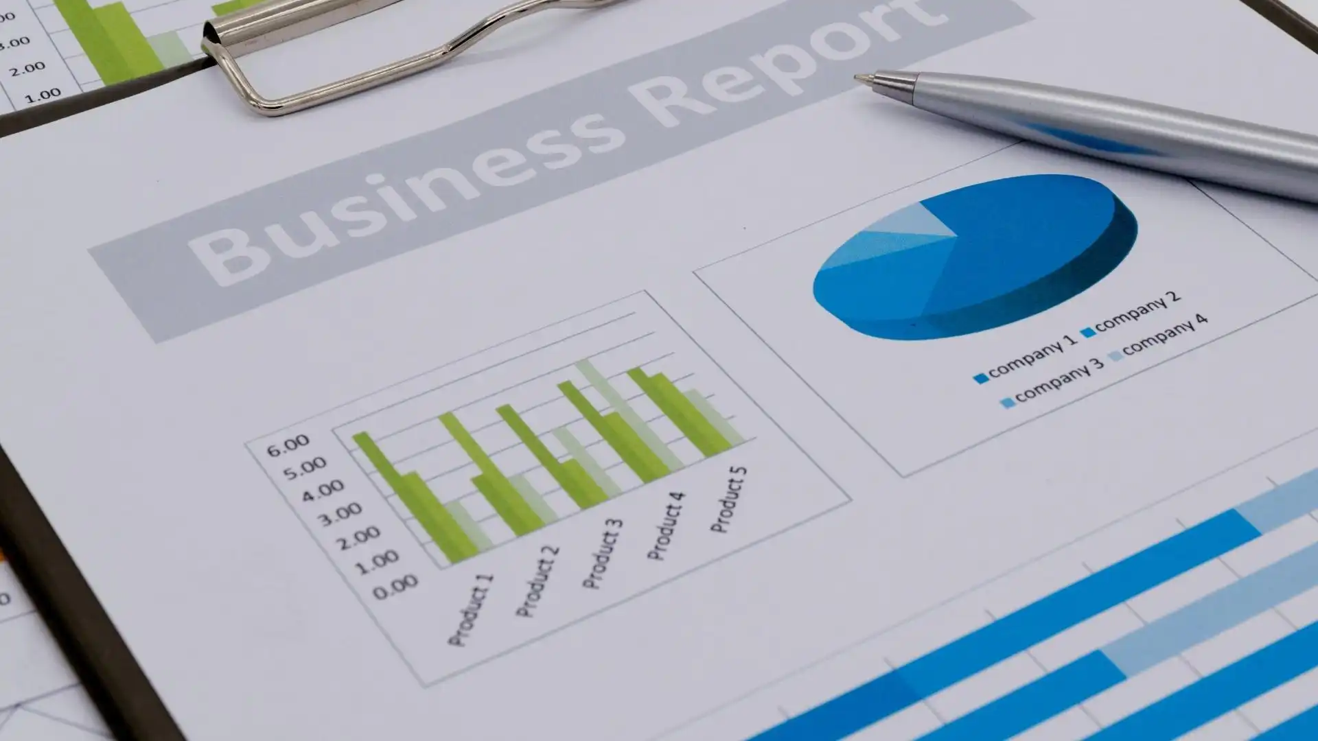 Close-up of a Montana Business economic report on a clipboard, featuring a bar chart and pie chart with product data, and a silver pen resting on the document—highlighting Secretary Jacobsens focus on data-driven insights.