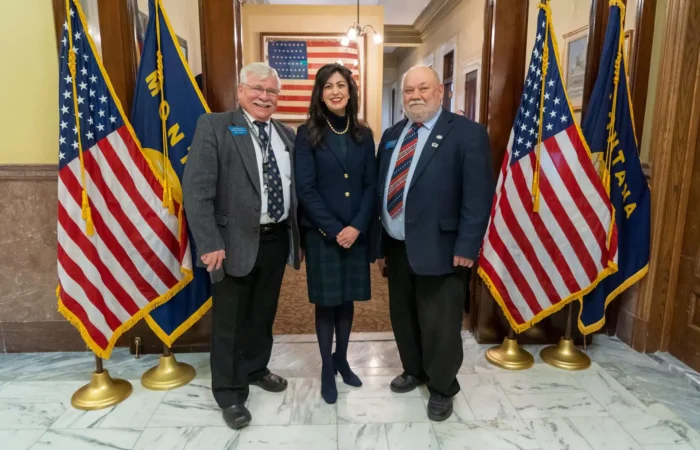 Montana's 2024 candidate filing period to begin on Thursday, January 11 5 Three people stand smiling in a hallway between two pairs of U.S. and Montana flags, dressed in business attire. An American flag hangs in the background, highlighting the significance of the 2024 election and Montana candidate filing season.