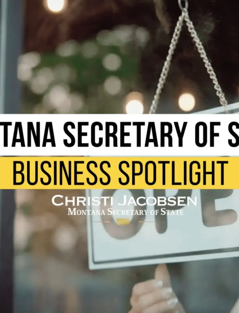 A person flips an OPEN sign on a glass door. Overlaid text reads: Montana Secretary of State Business Spotlight. Christi Jacobsen, Montana Secretary of State.