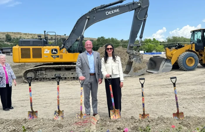 Secretary of State Christi Jacobsen joins community leaders at groundbreaking for St. Vincent Regional Hospital's 'once-in-a-generation' facility 7 Christi Jacobsen stands smiling with a companion in front of colorful shovels at the St. Vincent Regional Hospital groundbreaking, with a yellow excavator, bulldozer, and bright pink flowers completing the scene.