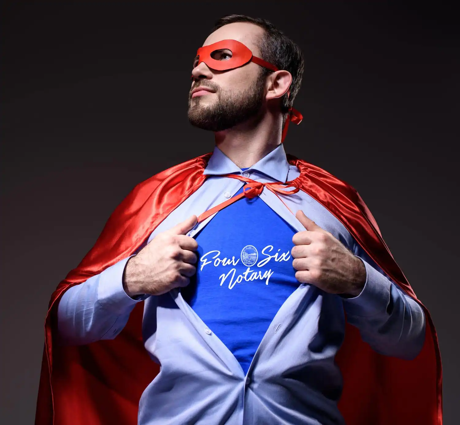 A man in a red superhero cape and mask opens his shirt to reveal a blue “Soul Sista Notary” t-shirt, posing confidently against a dark background—ready for the Notary Awards or to be named Notary of the Year.