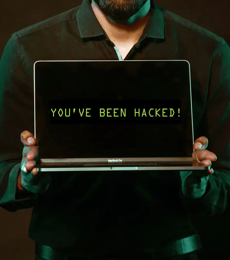 Secretary of State's Office takes part in Cybersecurity Awareness Month 3 A person in a dark shirt holds a laptop, with the screen displaying the message YOUVE BEEN HACKED! in green text on a black background.